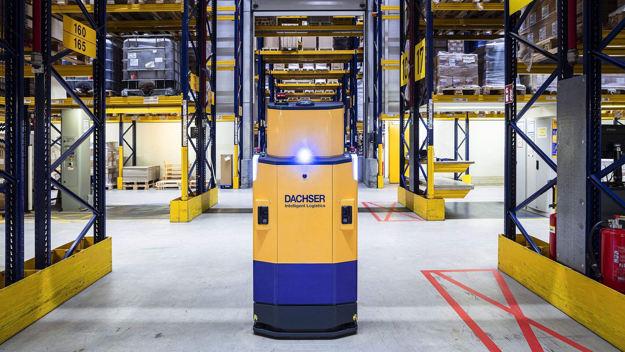Ein autonomes Fahrzeug (AGV) navigiert selbstst&auml;ndig durch ein DACHSER Warehouse.
 